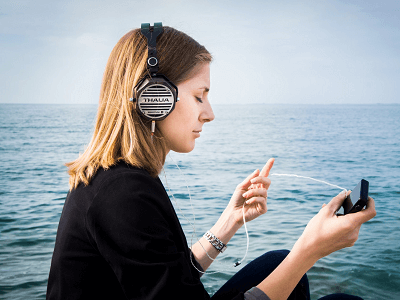 woman-listen-smartphone-sit-ocean.png
